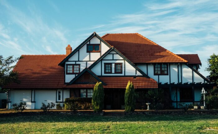 Großes Einfamilienhaus mit Garten unter blauem Himmel.