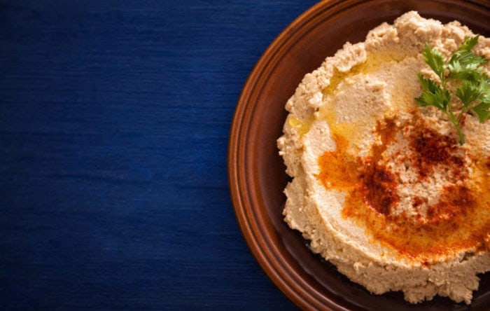 Hummus on a plate with parsley and olive oil on it Hummus on a plate with parsley and olive oil on it