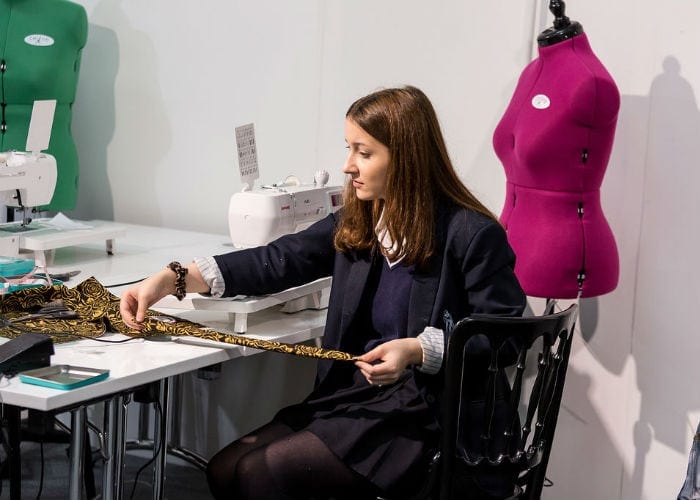 Young girl at a sewing machine at the Workshops at the Knitting and Stitching Show Alexandra Palace October