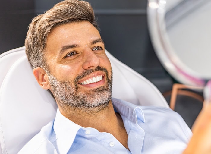 Man admiring his white teeth in a mirror
