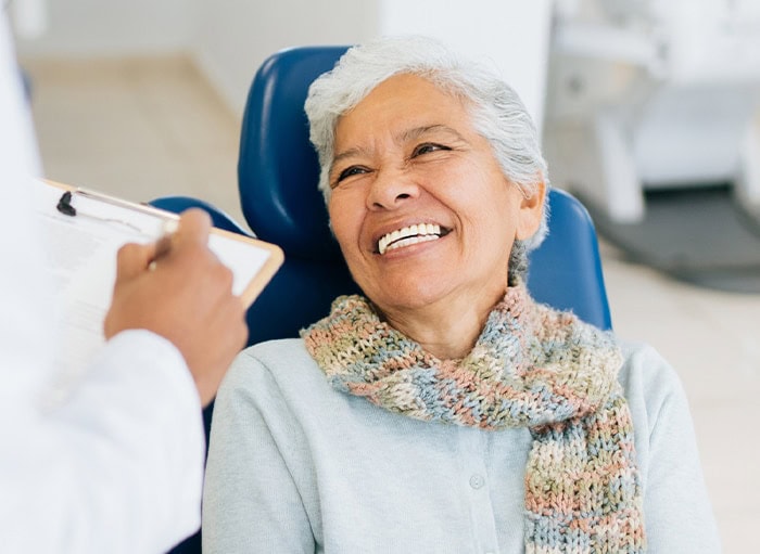 An elderly woman with white teeth