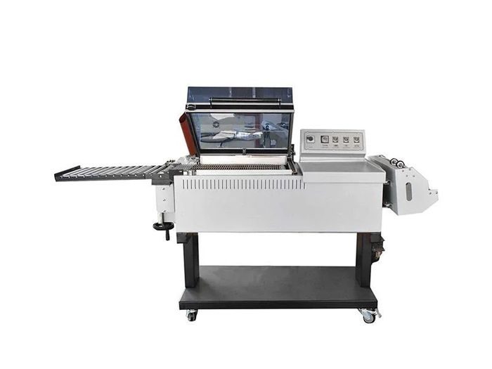 Automatic shrink wrapping machine with continuous film feed and heat tunnel