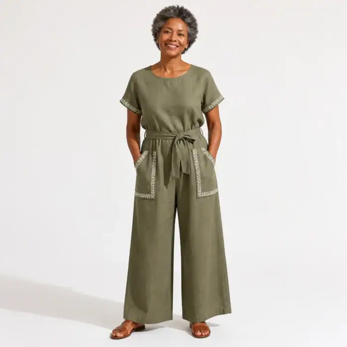 Woman in an olive linen jumpsuit with block-printed pocket trims