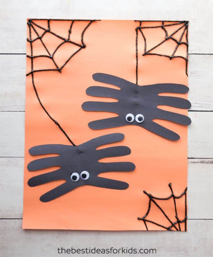 handprint spiders on orange background