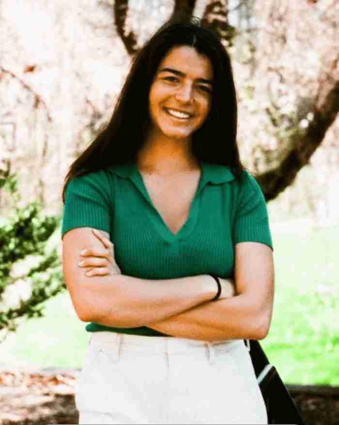 Lara Zammit, LLMSW, EMDR therapist near you in Michigan, smiling outdoors with arms crossed in a green polo shirt