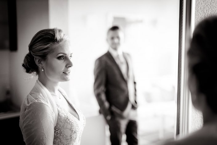 Spiegelung vom Brautpaar über einen Spiegel fotografiertes Hochzeitspaar, Braut im Vordergrund