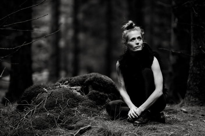 Licht & Schatten im Thüringer Wald sitzende Frau als Ganzkörper Portrait fotografiert in Schwarz Weiss im Thüringer Wald mit der Canon EOSR & RF 85mm f/1.2L USM