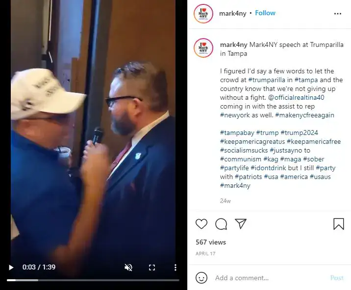 Mark Szuszkiewicz being handed a mic by Dion Cini. At the same event, Mr Cini was recorded on video shouting "White Pride!"