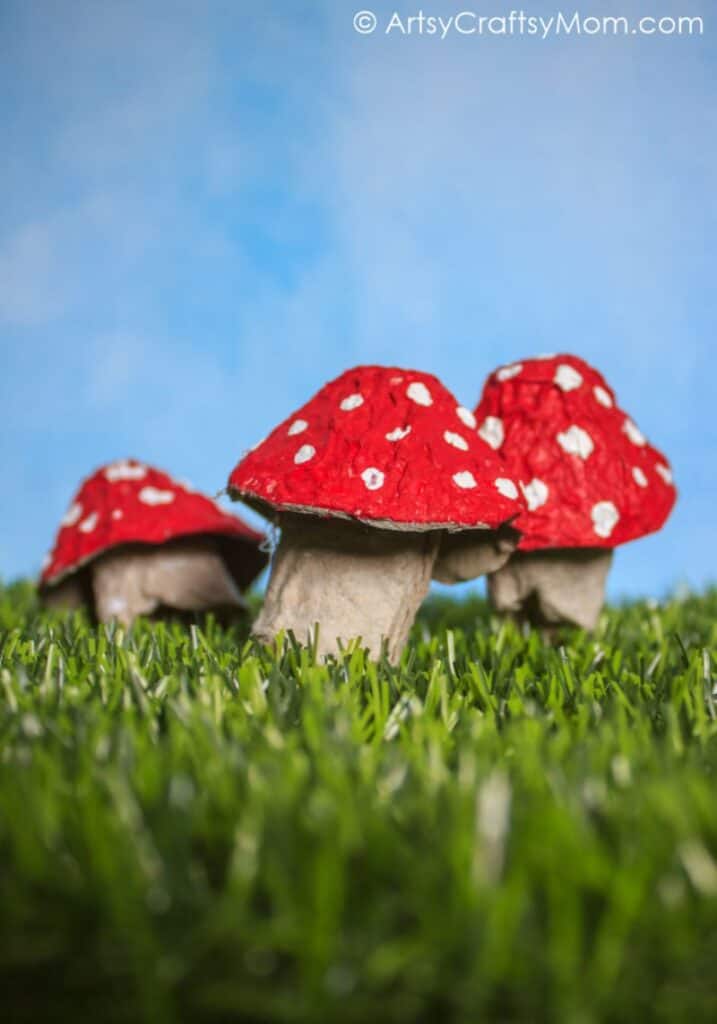 cardboard mushroom craft on grassy and blue sky backdrop