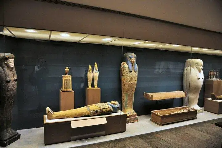 Painted coffins and funerary objects inside a glass case