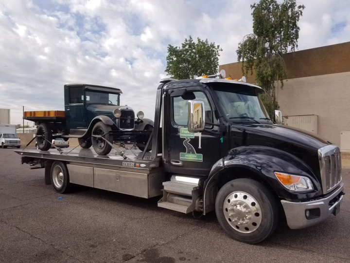 1920 Ford Model AA being towed on a flatbed