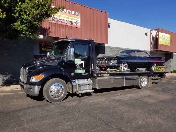 1960 Chevrolet Impala sport coupe being towed on a flatbed