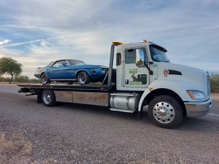 1973 Ford Mustang convertible being towed on a flatbed in Scottsdale, AZ