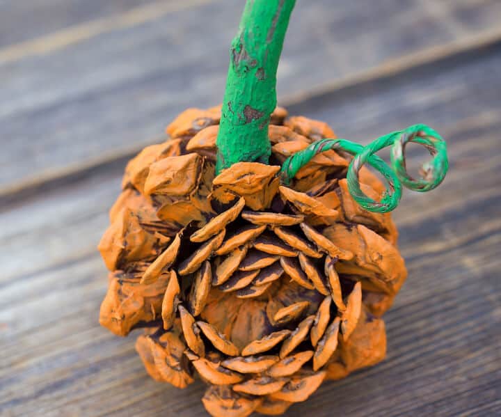 DIY craft for kids of orange pumpkin made with pine cones