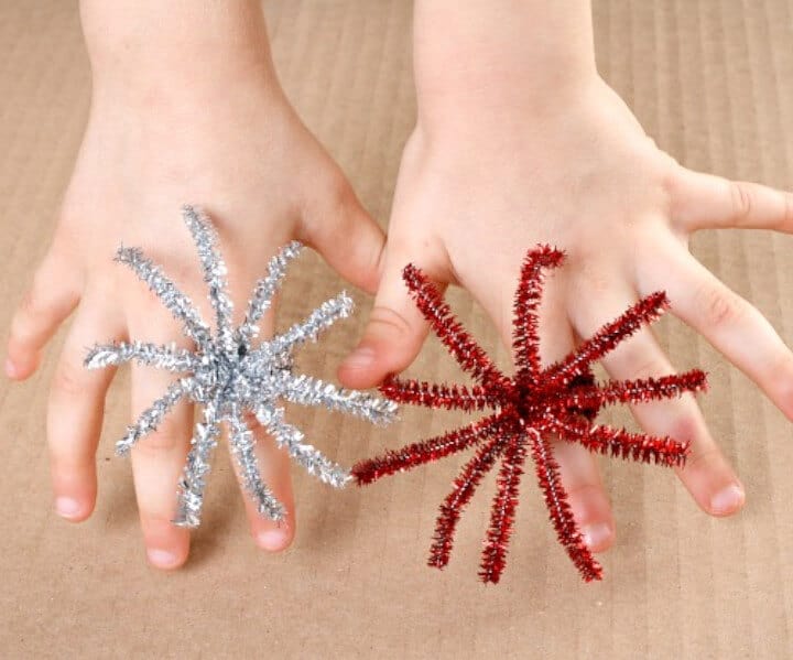 kid's hand wearing red and silver fireworks rings