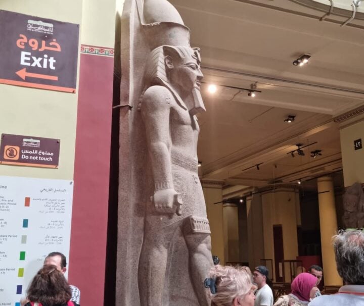 Touristen bestaunen eine antike Statue im Ägyptischen Museum in Kairo während eines Marsa Alam Pyramiden Ausflugs.