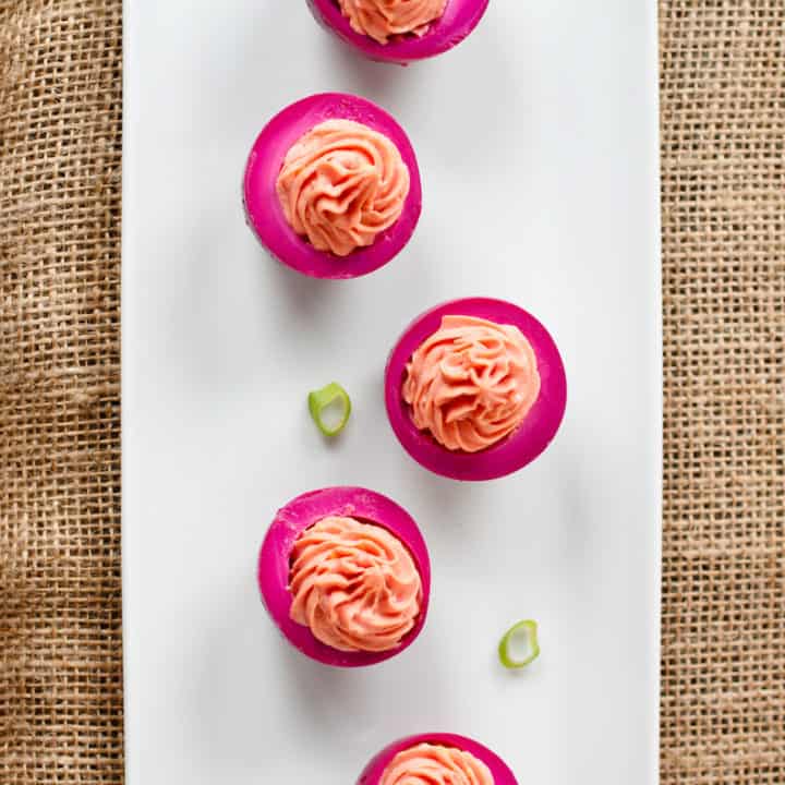 Beet-pickled eggs have a bright fuchsia exterior and a creamy sweetness from beet brine. Eat this Pennsylvania Dutch specialty plain or as deviled eggs. #beetpickledeggs #deviledeggs
