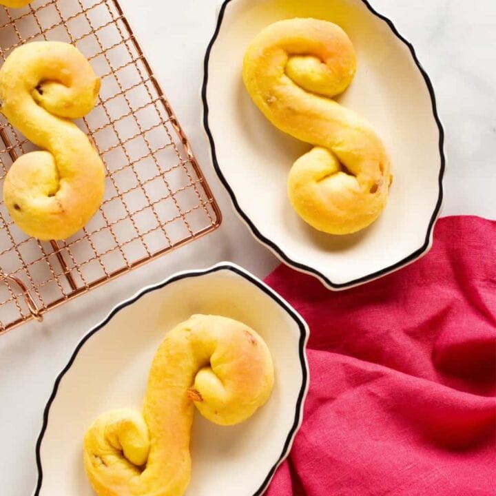 s-shaped Swedish saffron buns, or lussekatter, on plates