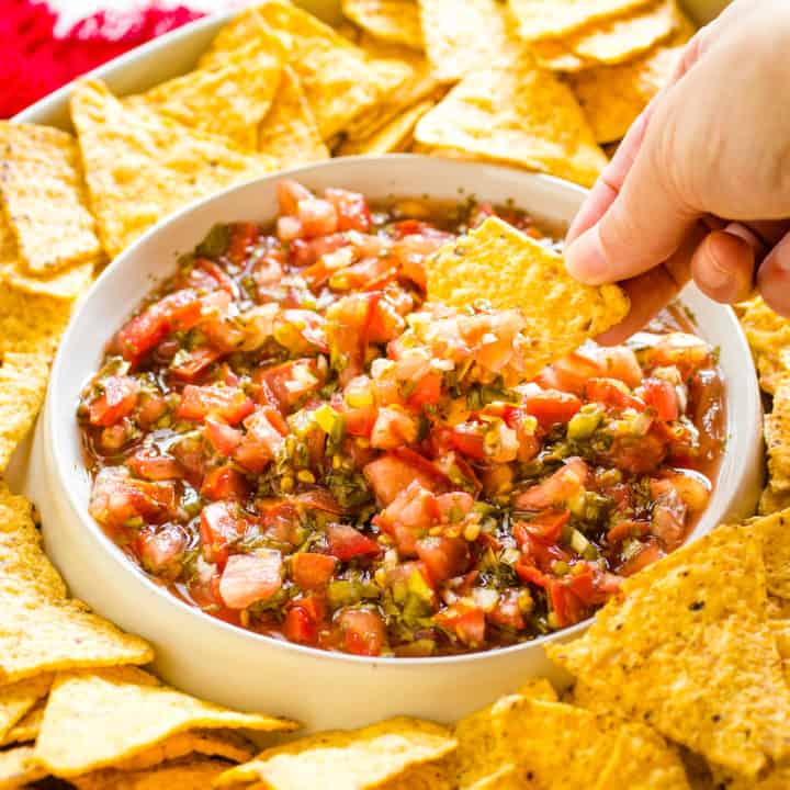 dipping a chip into fermented salsa