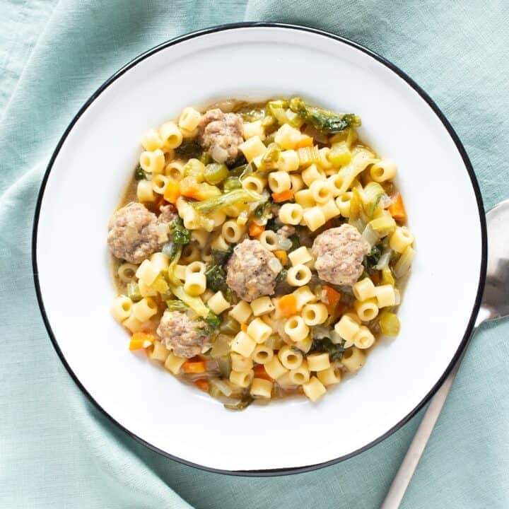 bowl of Italian wedding soup with tiny meatballs and tube pasta
