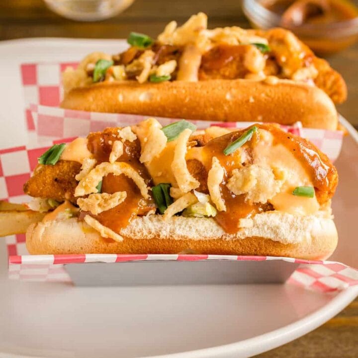 Bird Dawgs with chicken tenders, beer cheese, bbq sauce and onions in a hot dog bun