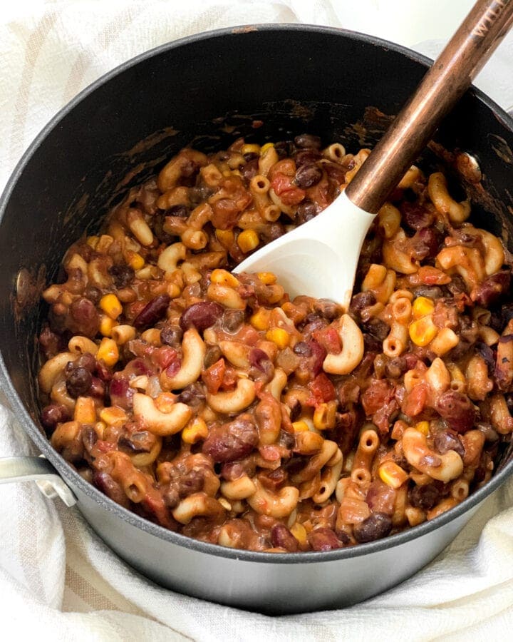 vegetarian mac with black beans in a pot with a spoon