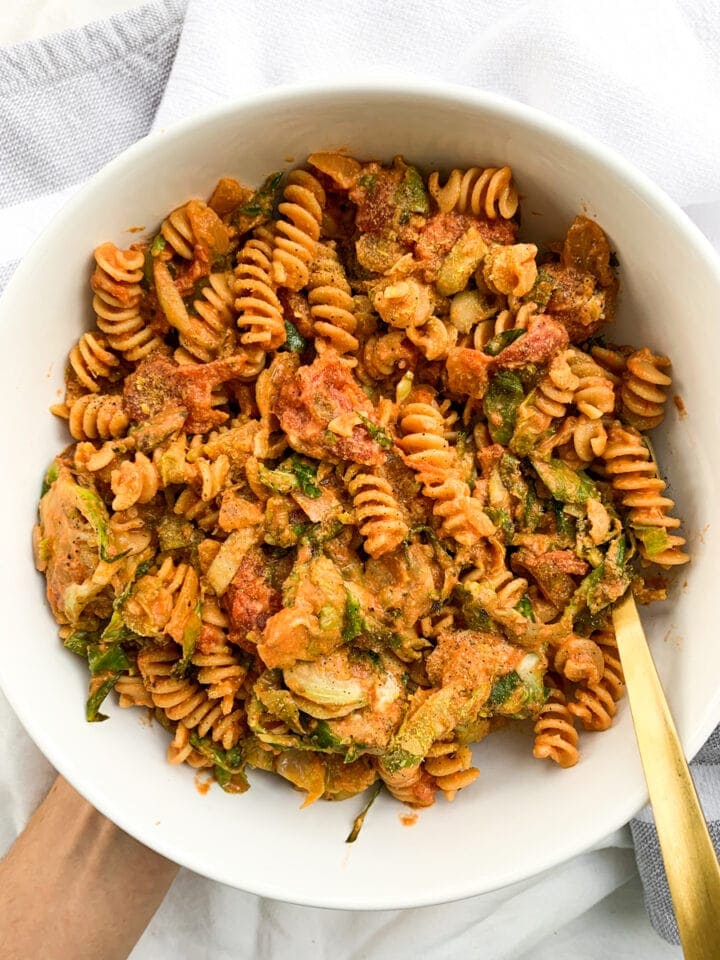 top view of goat cheese pasta in a white bowl with a gold fork