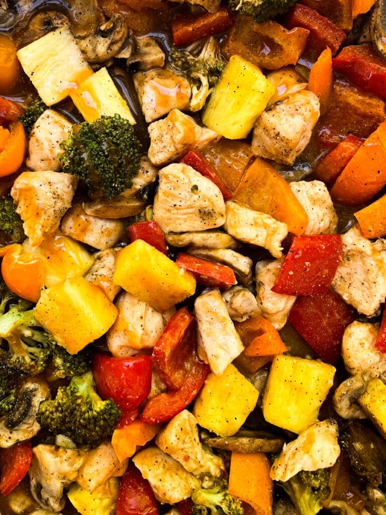 close up of hawaiian chicken and vegetables on a sheet pan