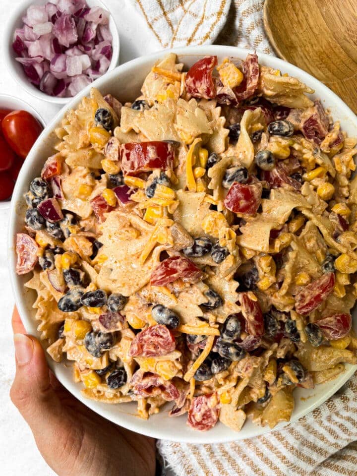hand holding bowl of taco pasta salad