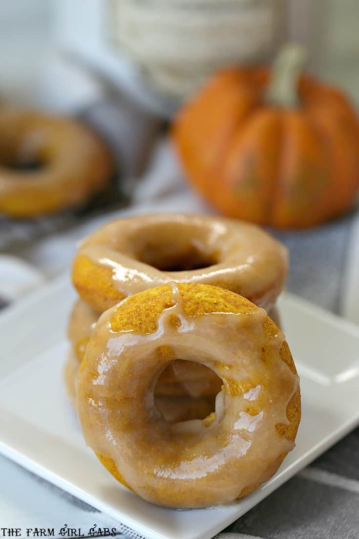 These moist and fluffy Maple Glazed Pumpkin Doughnuts are baked, not fried and are really easy to make. #doughnuts #pumpkin #fallrecipe #dessert