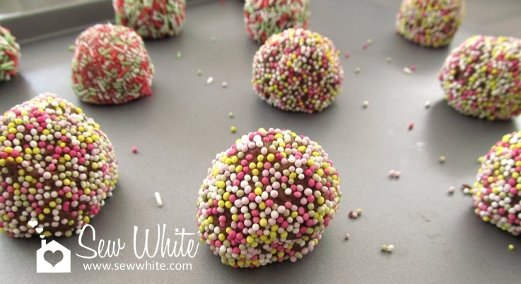 cookie dough balls covered in sprinkles ready to bake