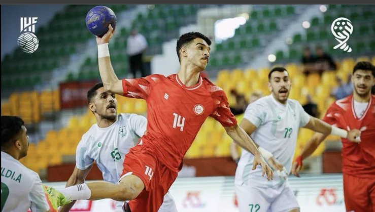 alt="Un joueur marocain U18 de handball en extension lors d’un tir face à la défense adverse pendant le Mondial 2025"