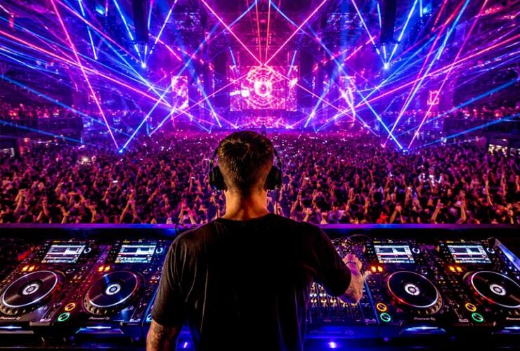 Koncert muzyki techno widziany zza pleców DJ'a