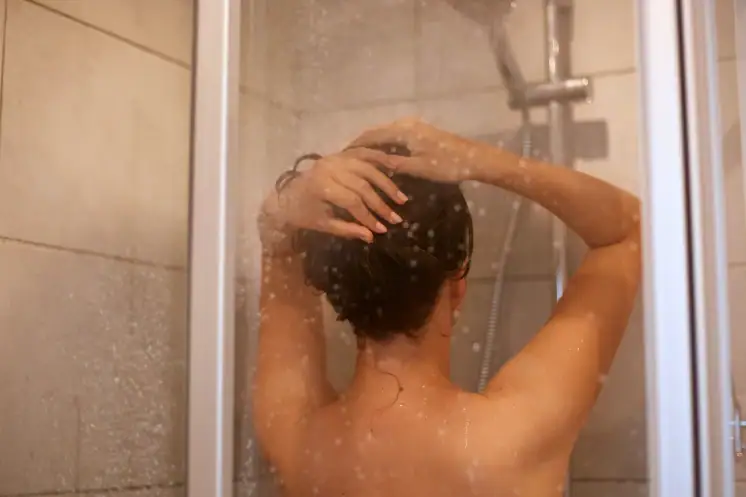 Vrouw wast haar haar onder de douche