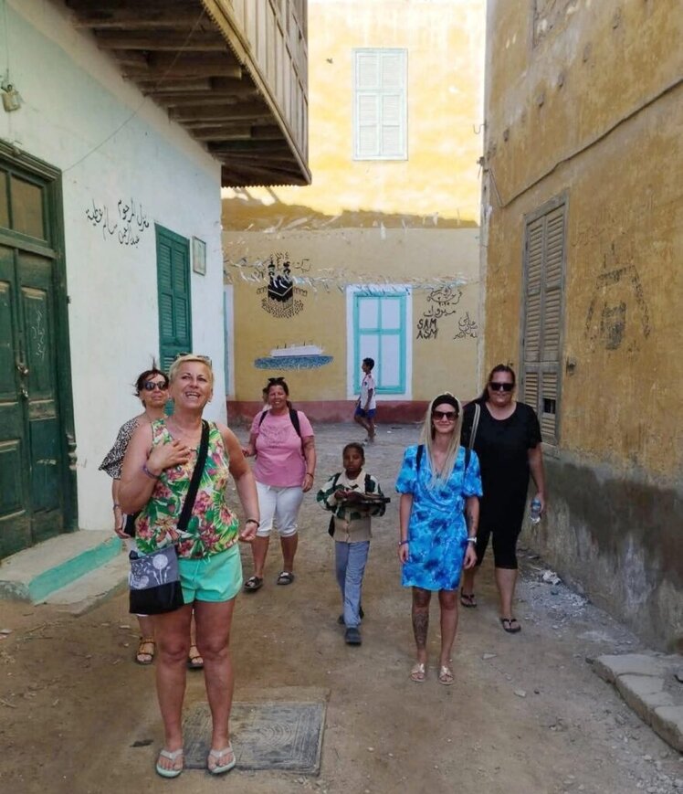 Deutsch: „Touristen von Marsa Alam Reisen spazieren glücklich durch ein ruhiges Viertel in El Quseir – ein Beispiel dafür, dass ist el quseir gefährlich im Alltag für Besucher eher unbegründet ist“ 