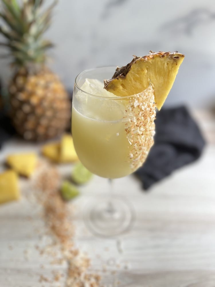 Piña Colada Sangria 1 Piña Colada Sangria in a stemmed wine glass with pineapple wedge as garnish