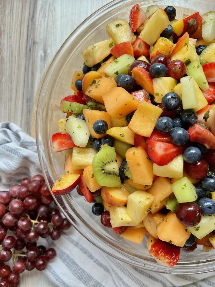 Summer Fruit Salad 1 Summer Fruit Salad in a large serving bowl next to a bunch of grapes