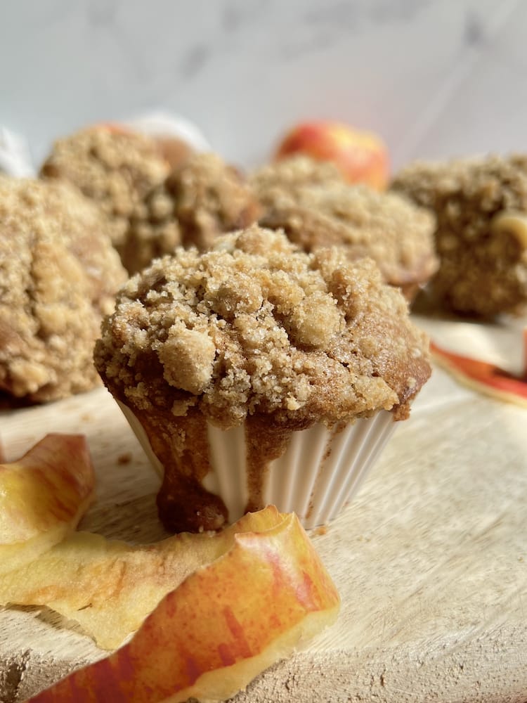 Apple Streusel Cheesecake Muffins 1 Apple Streusel Cheesecake Muffins on a cutting board with apple peels