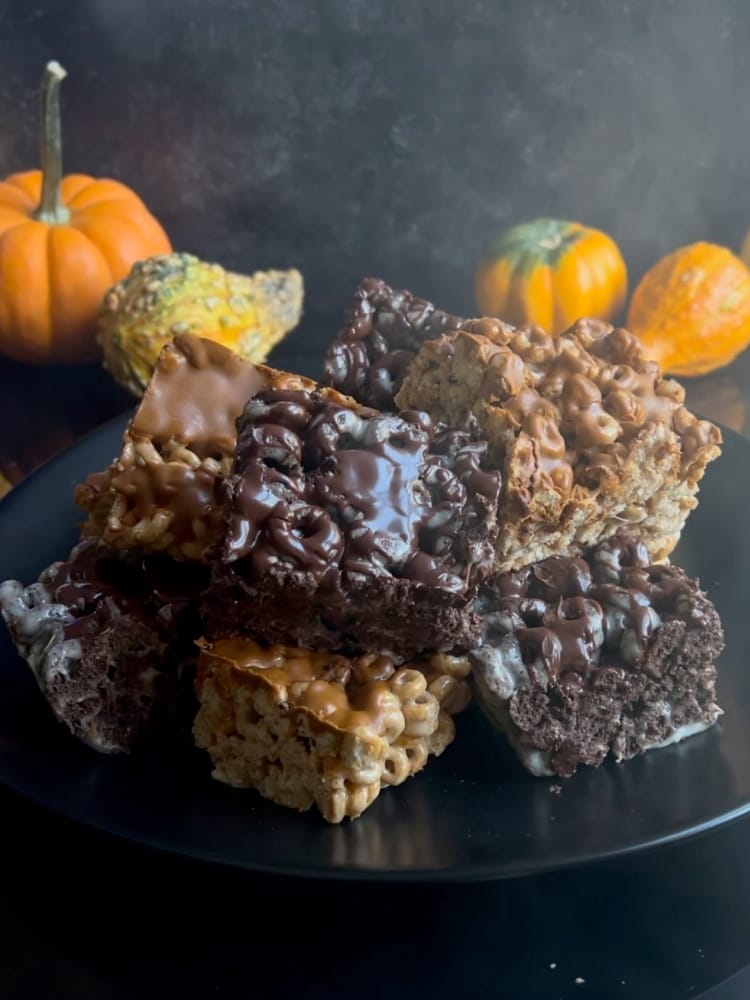 Halloween Marshmallow Treats 1 Halloween Marshmallow Treats on a black plate with small pumpkins in the background