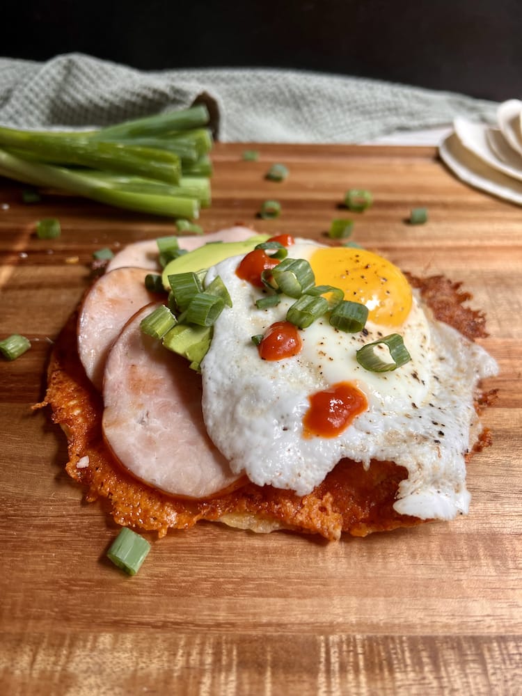 Crispy Cheese Breakfast Tostada 3 copy Crispy Cheese Breakfast Tostada on a wooden cutting board with fresh scallions in the background
