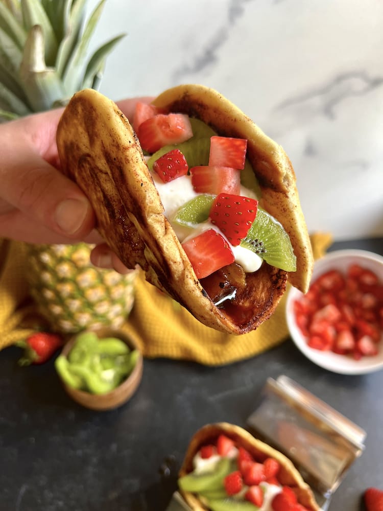 Cinnamon Bun Dessert Tacos 5 WEB Cinnamon Bun Dessert Tacos with one held in hand toward the camera