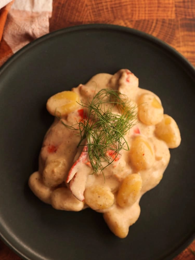 Lobster & Gnocchi - 1 WEB Lobster and Gnocchi with Fennel Cream Sauce on a black plate