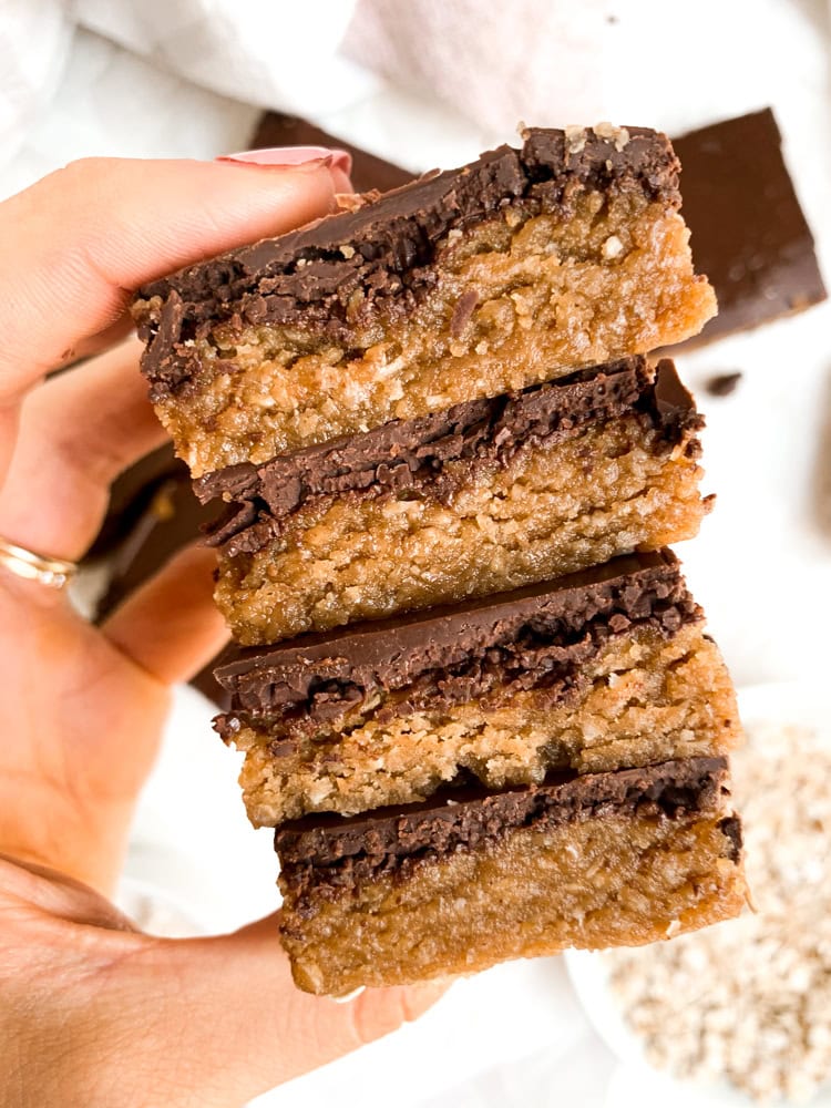 holding a stack of 4 cookie dough bars after chocolate has set