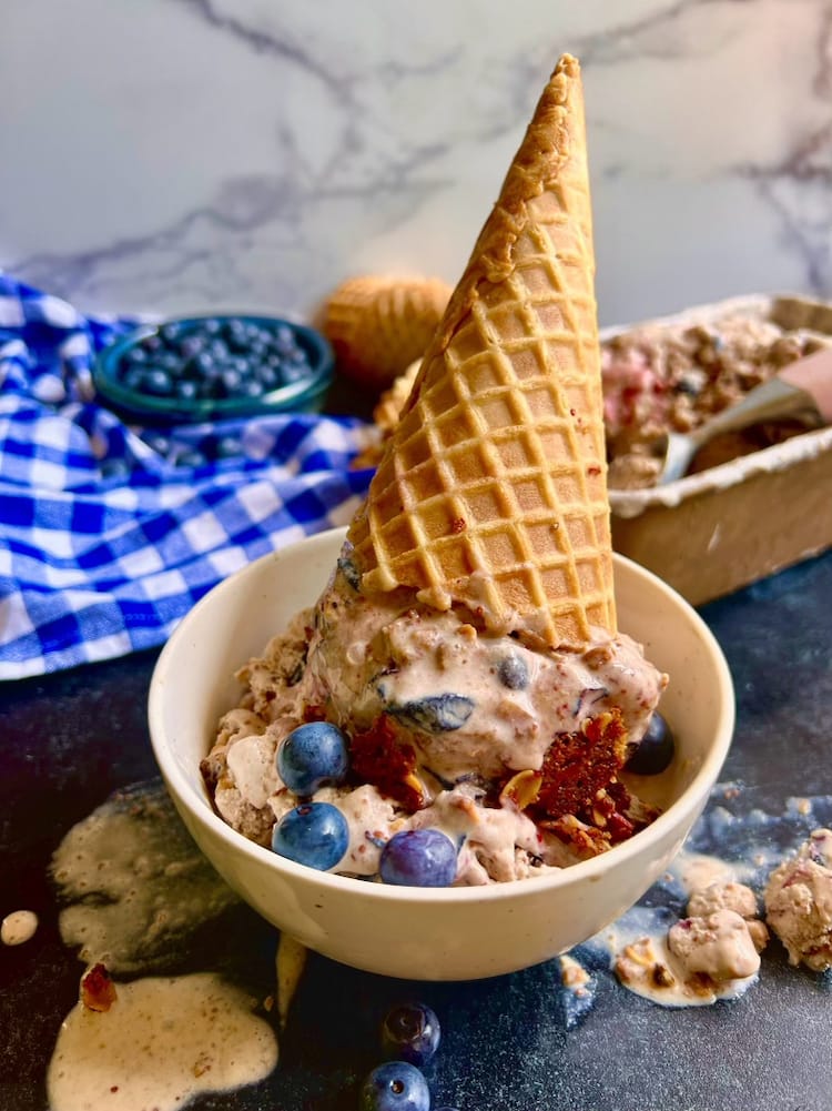 Blueberry Crisp Ice Cream 1 Blueberry Crisp Ice Cream in an upside down ice cream cone placed in a white bowl
