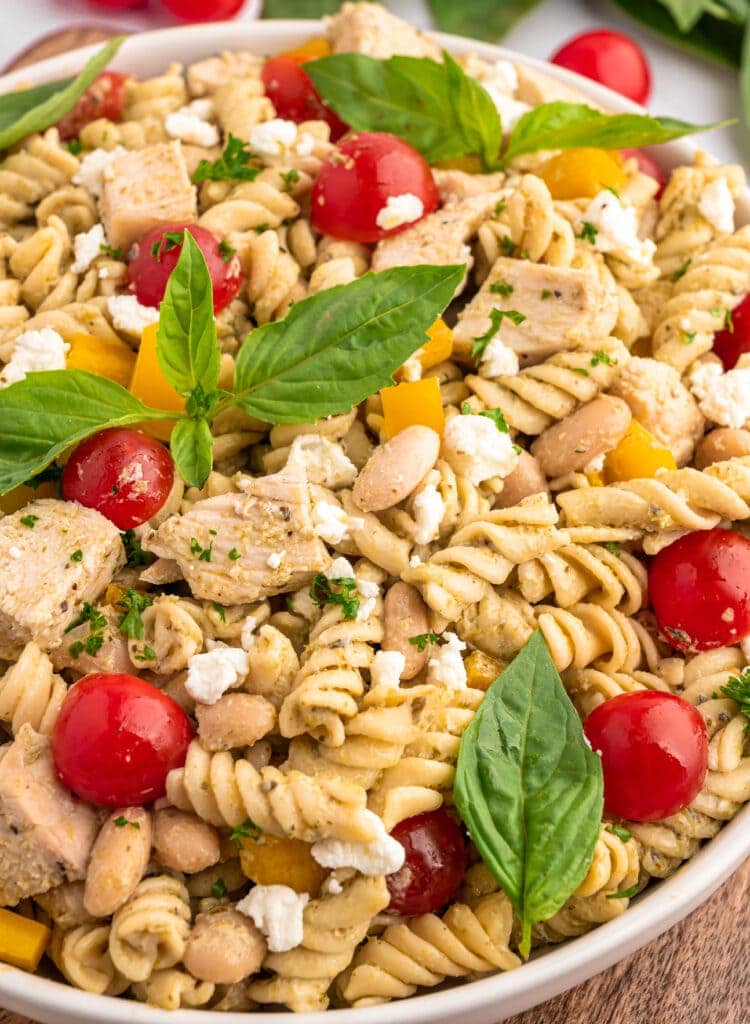 A bowl of High Protein Pasta Salad garnished with basil.