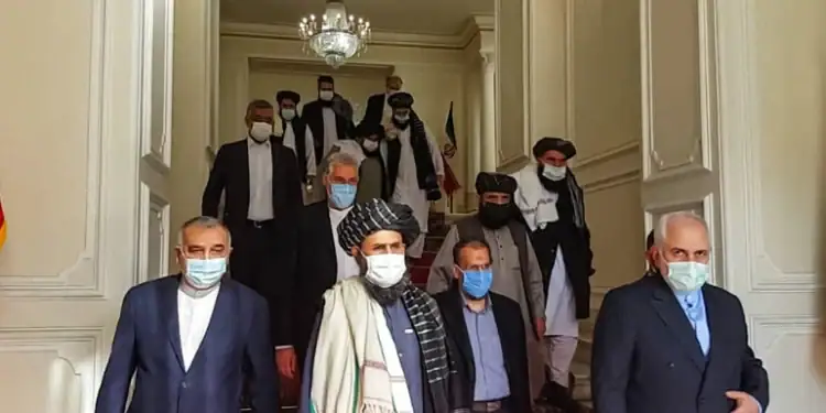 An image shows former Iranian Foreign Minister Mohammad Javad Zarif meeting with Taliban official Mullah Abdul Ghani Baradar in Tehran last year