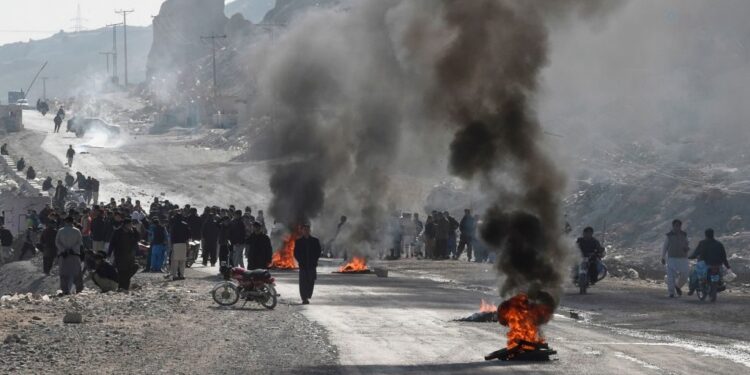 TOPSHOT – Members of Shiite Hazara community burn tyres during a protest after the killing of 11 workers of their community, in Quetta on January 3, 2021. (Photo by BANARAS KHAN/AFP via Getty Images)