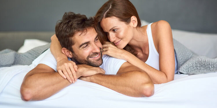 A man and woman laying on a bed