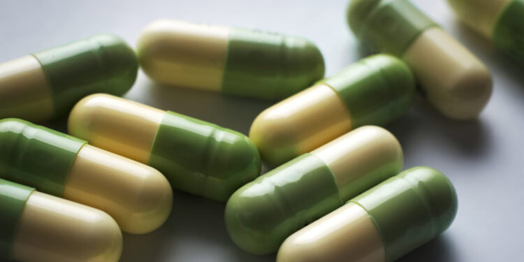 Capsule pills with green and yellow color for mental health or nutritional supplements.