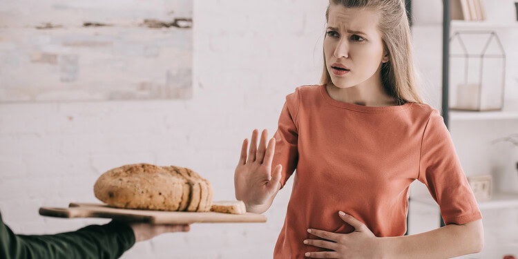Stunned woman refusing bread at the table, rejecting food in a grocery store or restaurant setting.